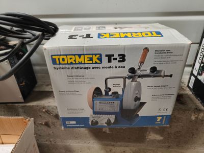 une boîte à outils posée par terre à côté d'une boîte de câbles