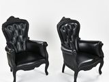 pair of black leather armchairs with carved arms and arms