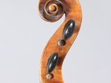 a close up of the back of a violin with a fiddle in the foreground