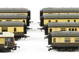 several yellow and black train cars sitting next to each other on a white surface