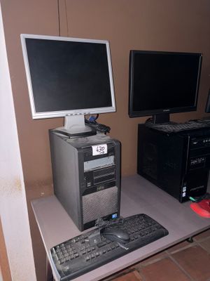 un ordinateur de bureau posé sur un bureau, à côté d'un écran et d'un clavier