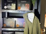 un manteau vert accroché à un portant dans un magasin