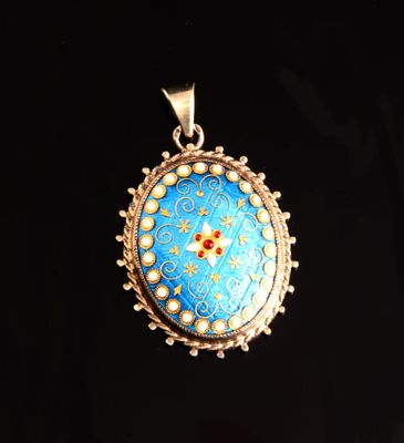 un gros plan d'un pendentif bleu et or sur fond noir