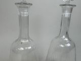 two clear glass vases sitting next to each other on a table