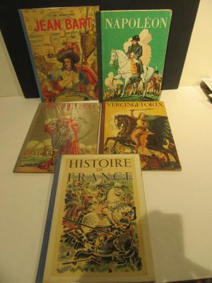 Plusieurs livres sont posés sur une table devant un miroir.