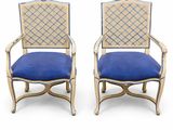 pair of blue upholstered chairs with gold trim and blue upholstered cushions