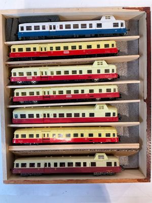 une boîte en bois contenant tout un tas de petits trains