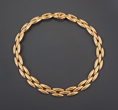 un collier en or avec un motif tressé sur fond noir