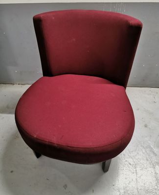 a red chair sitting on top of a white floor next to a wall
