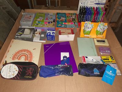 de nombreuses fournitures scolaires posées sur la table, prêtes à être rangées
