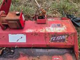 une tondeuse à gazon rouge qui est posée dans l'herbe
