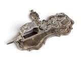 une assiette en argent ornée d'un oiseau sur un fond blanc