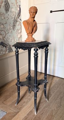 une petite table sur laquelle est posé un buste