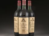 three bottles of wine sit on a table in front of a black background