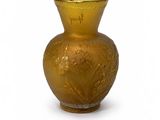 a gold vase that is sitting on a white surface