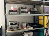 de nombreux appareils électroniques sur les étagères de la pièce