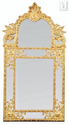 an ornate gold mirror with a bird on it