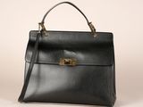a black leather handbag with gold hardware