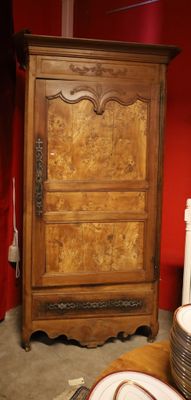 une armoire en bois dans une pièce rouge, avec des assiettes par terre