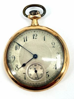 a close up of a pocket watch on a white surface