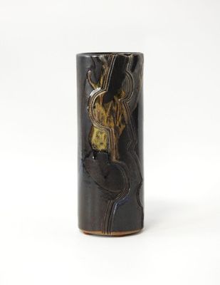 un gros plan d'un vase noir posé sur une surface blanche