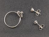 three pieces of silver jewelry on a black surface
