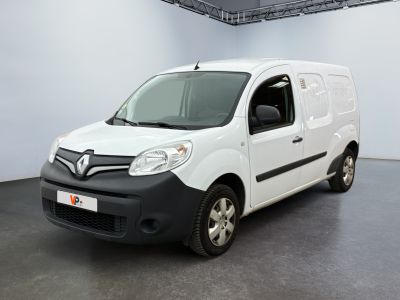 La camionnette blanche est garée dans une grande pièce au sol noir.