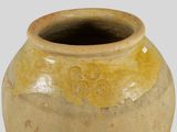 a yellow vase that is sitting on a white surface
