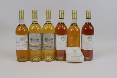 six bottles of wine sitting next to each other on a white surface