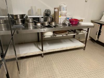 de nombreuses casseroles et poêles posées sur une table en acier inoxydable