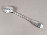 une cuillère en argent avec un manche de cuillère sur une table