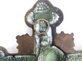 a green and white statue with a gold ring on it
