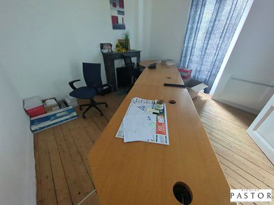 une photo d'un bureau dans une pièce où se trouvent de nombreux livres