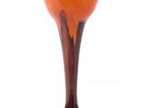 an orange glass vase with a black base on a white background