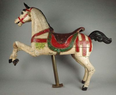 un cheval de bois recouvert d'une couverture rouge et verte sur le dos