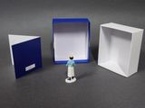 a small figurine that is standing in front of a box