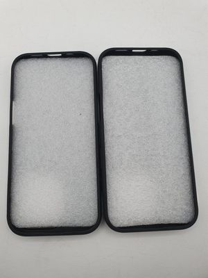 two black cell phones sitting side by side on a white surface