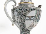 a white and blue vase with a handle on it