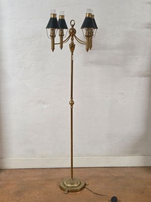 an antique brass floor lamp with black shades on a wooden floor
