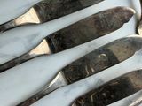 five forks and a spoon on a marble table