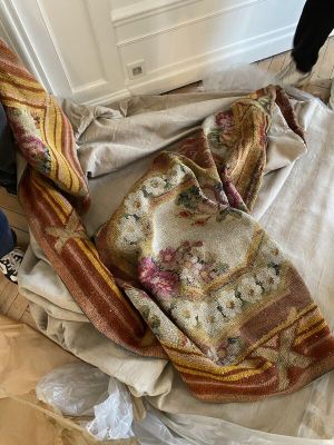 une personne debout à côté d'un tas de vêtements posé par terre