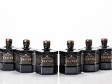 six bottles of liquor lined up in a row on a white surface
