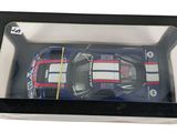 a toy car in a plastic box on a white surface