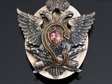 an image of a silver and gold broochle with a crown on it