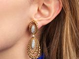 un gros plan sur une femme portant une paire de boucles d'oreilles