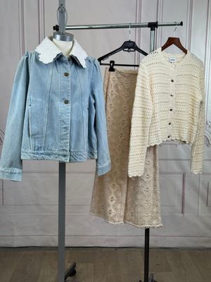two jackets and a skirt on a rack in a room