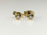 un gros plan sur une paire de boucles d'oreilles en or et diamants
