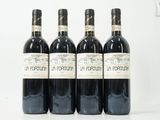 quatre bouteilles de vin rouge sont alignées sur une table