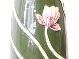 a green vase with a pink flower on it