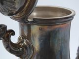 a silver vase that has a handle on it